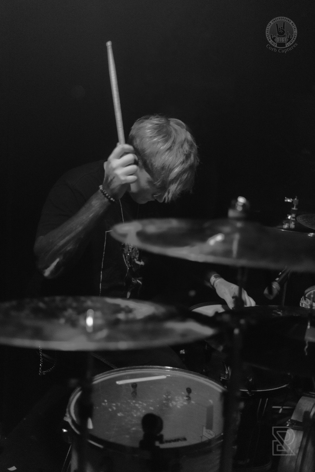 Portrait of Diggity Glover drumming, dramatic spotlight
