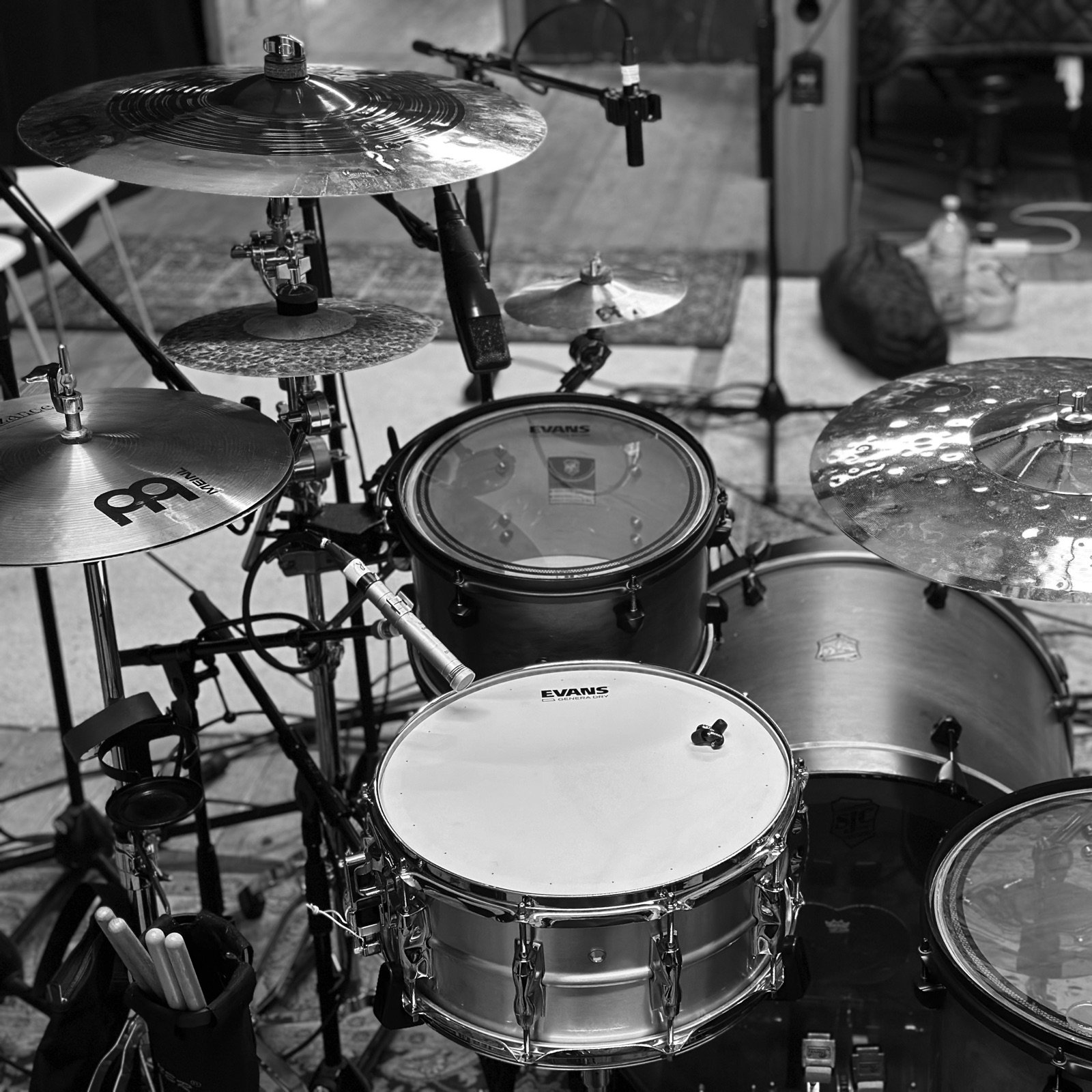 Studio drum kit setup with cymbals and microphones, black and white