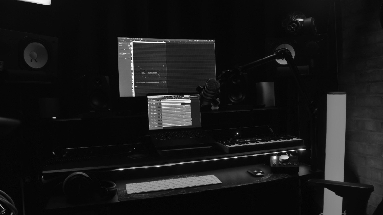 Mixing desk and studio monitors in a darkened control room